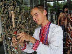 Young man weaves a camouflage net