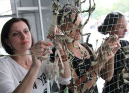 Women weave camouflage nets