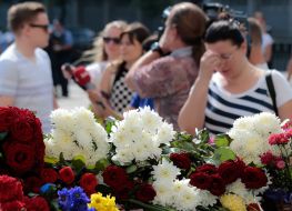 People laying flowers to the portrait of Igor Debrin