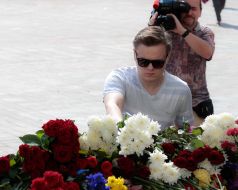 People laying flowers to the portrait of Igor Debrin