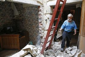 An elderly man in a dilapidated house
