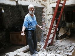 An elderly man in a dilapidated house