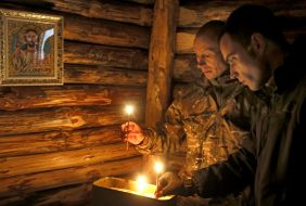 Soldiers put a candle in the chapel