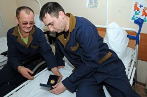 Боец, раненный в зоне проведения АТО, рассматривают награды