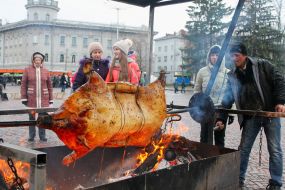 A man prepares a pig on a spit