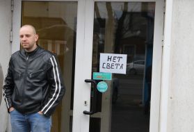 Мужчина стоит возле витрины магазина