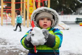 Мальчик держит снежок