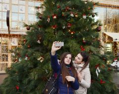 Девушки фотографируются возле новогодней елки