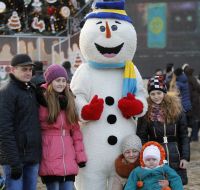 Family is photographed with a man in a suit Snowman