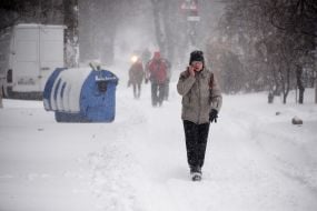 Мужчина идет по заснеженной улице