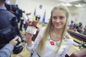 Девушка держит паспорт в  форме ID-карты