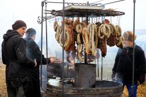 Мужчины коптят сало и колбасы