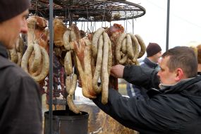 Мужчины коптят сало и колбасы