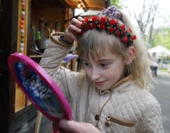 The girl measures the wreath