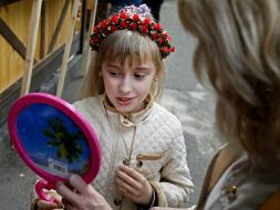 The girl measures the wreath