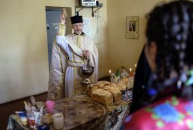 The priest consecrates Easter cakes in jail