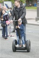 A man with a child riding a Segway