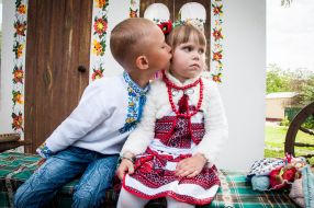 Мальчик целует девочку