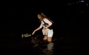 Девушка пускает венок на воду