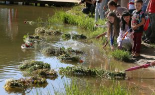 Girls let wreaths of wild flowers on the water