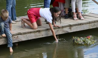 The girl let a wreath of wild flowers on the water