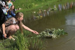 The girl let a wreath of wild flowers on the water