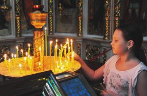 A girl puts a candle