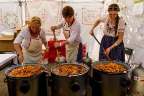Women cook goulash at the fair