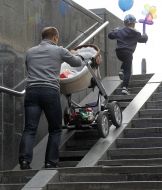 Чоловік вивозить дитячий візок з підземного переходу