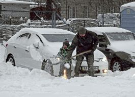 Man with his son dig the car out of the snow