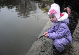 Девочка держит в руке рыбу