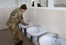 A soldier washes his hands