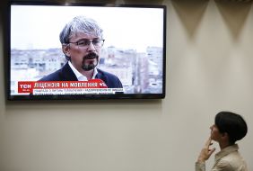 Girl watches the news on the TV channel "1+1"