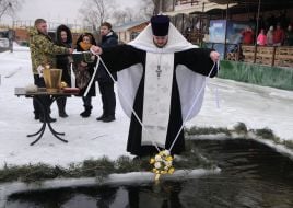 Священник освящает прорубь