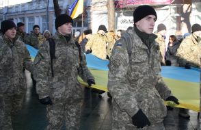 Soldiers carry a huge flag of Ukraine
