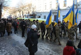 Soldiers carry a huge flag of Ukraine
