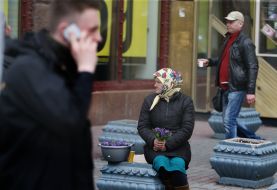 Літня жінка продає квіти