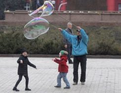 The man shows the kids huge bubbles