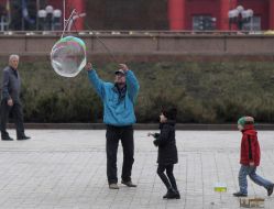 The man shows the kids huge bubbles