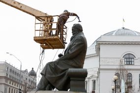 Worker cleaning company washes monument to Mikhail Grushevsky