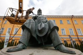 Worker cleaning company washes monument to Mikhail Grushevsky