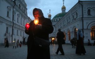 Віруючі несуть запалені свічки додому