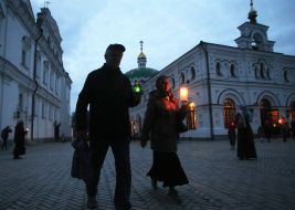Віруючі несуть запалені свічки додому