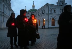 Віруючі несуть запалені свічки додому