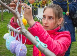 Easter Egg girl hangs on a tree