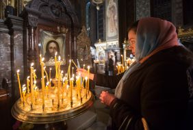 A believer puts a candle