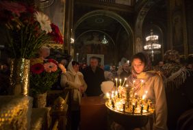 A believer puts a candle