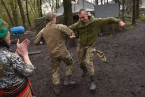 Volunteers dance with the military