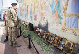 Soldiers looking at photos of dead defenders of Ukraine