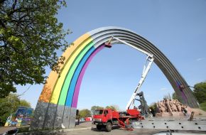 Communards pasting the Arch of Friendship of Peoples with colorful film